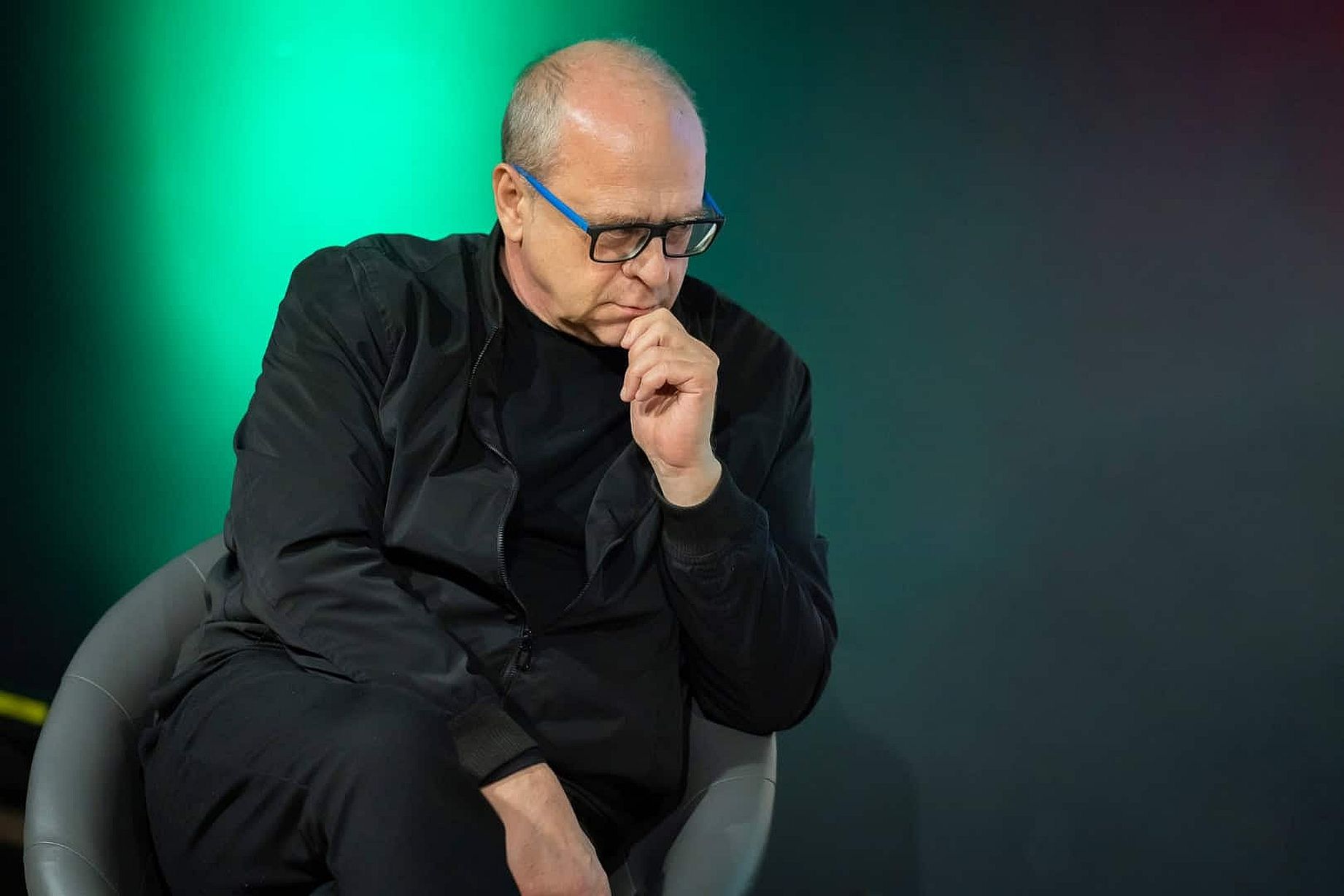 Widoczny na zdjęciu mężczyzna to Jerzy Jarniewicz, polski poeta, krytyk literacki, tłumacz i eseista. Jest on profesorem Uniwersytetu Łódzkiego i laureatem prestiżowej Nagrody Literackiej „Nike” 2022 za tom poezji „Mondo cane”. Na zdjęciu Jarniewicz jest uchwycony podczas publicznego wystąpienia lub spotkania autorskiego