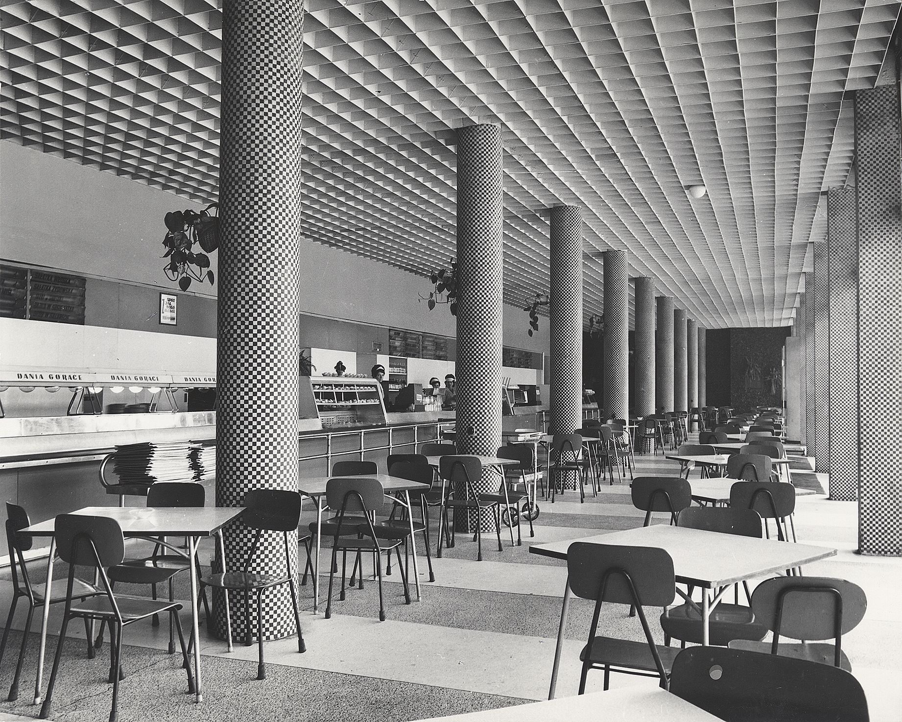 Czarno białe zdjęcie wnętrza baru, mozaika na słupach, kartonowy sufit, dużo światła