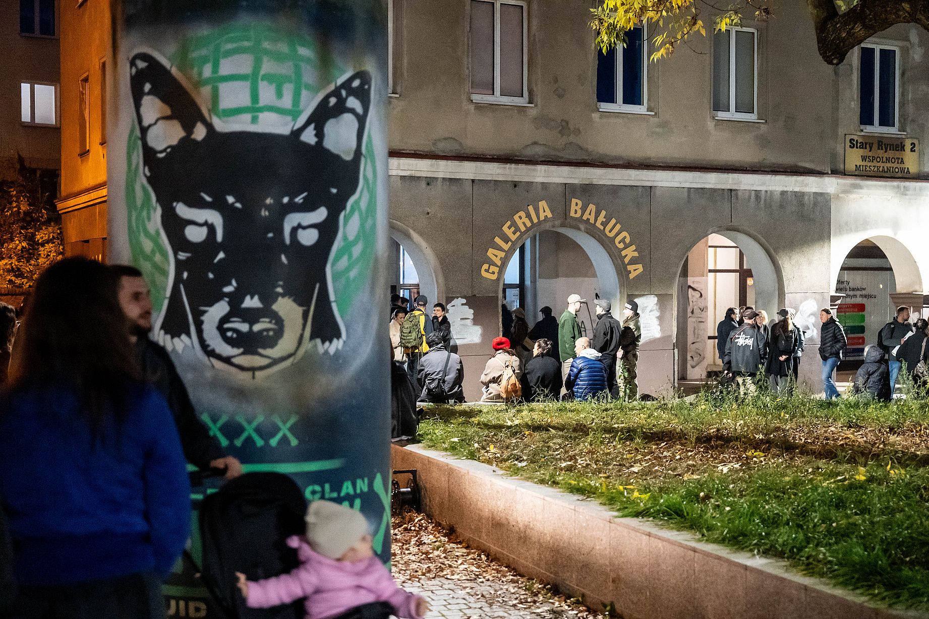 Tłum przed galerią na otwarciu wystawy, po lewej stronie ogromna puszka z namalowanym psema