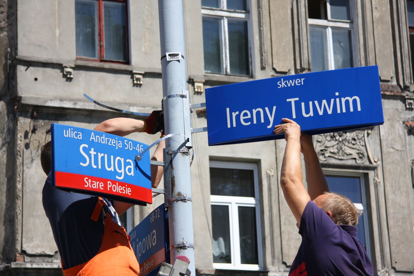 dwaj mężczyżni montują tabliczkę z nazwą ulicy Ireny Tuwim