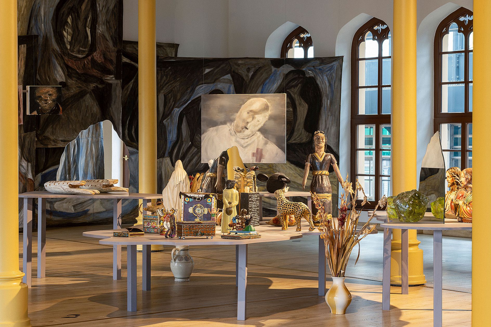 Zabytkowe wnętrze galerii, dużo figurek na stołach, obrazów w tle