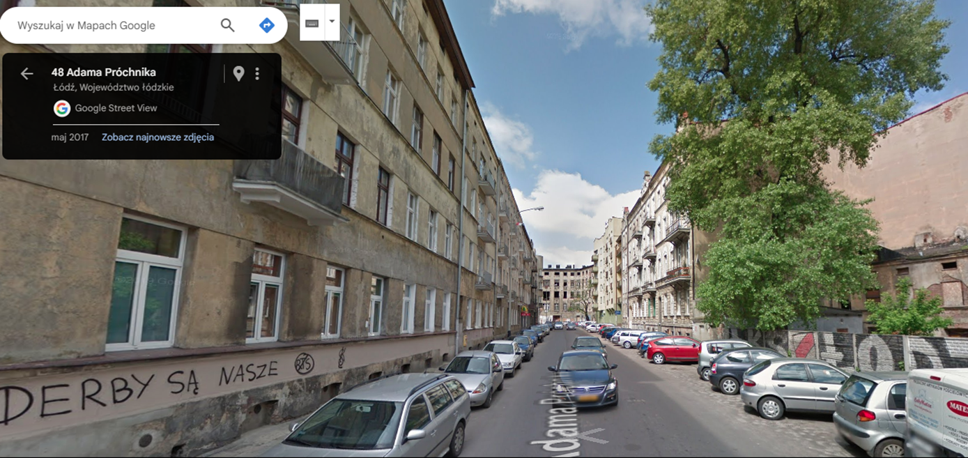 Ulica z dużą ilością aut, na budynku z boku napis: Derby są nasz